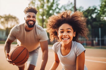 African american dad and daughter playing basketball. Father teaching daughter to play basketball. Family doing sports together and being active.