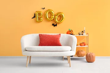 Fotobehang Sofa and text BOO made of balloons hanging on orange wall in living room © Pixel-Shot