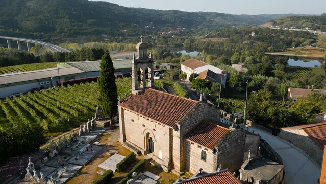 Iglesia Santa Maria de Fea in Toen Ourense Galicia Spain, golden hour light on facade and grassy cemetery