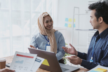 Obraz premium Group of young Asian business people talk, consult, discuss working with new startup project idea presentation analyze plan marketing and investment.