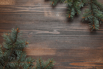 Beautiful fir branches on brown wooden background