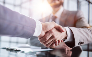 Handshake of two businessmen who enters into the contract to develop a new software to improve...