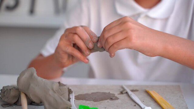 Teenager Boy At Art School Clay Sculpt in Art Class. Middle school kid learning how to create with help of teacher