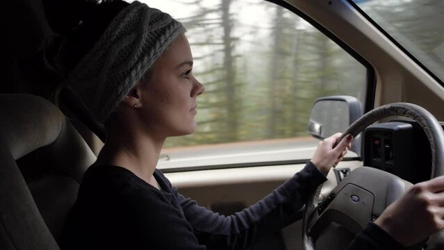 Young pretty woman driving vintage ford van in the pacific northwest
