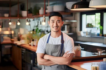 Keuken spatwand met foto an Asian man in an apron preparing to cook in the kitchen © A Denny Syahputra