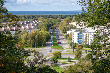 
panoramic view of the city between the trees and the sea beyond