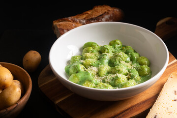 Food concept Spot focus Homemade creamy pesto gnocchi on black background with copy space