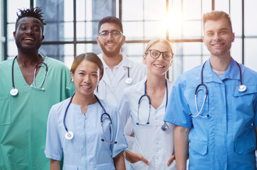 Professional Multinational Doctors Camera Posing. Teamwork Connection. Hospital Team. Cheerful Medicians.