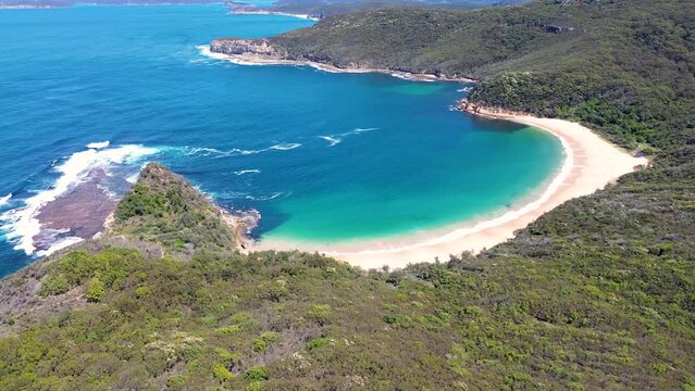 Drone aerial landscape pan shot of Maitland Bay Bouddi National Park ocean water bushland coastline NSW travel tourism Central Coast Australia 4K