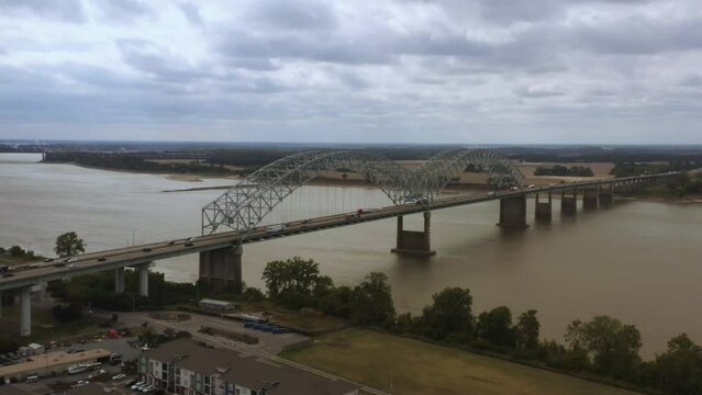 Aerial tracking shot of the Hernando De Soto bridge in Memphis Tennessee looking back at West Memphis, Arkansas.