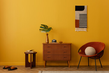 Minimalist composition on vintage living room interior with patterned killim rug, red armchair, stylish wooden sideboard, burgund stool, yellow wall and personal accessories. Home decor. Template.