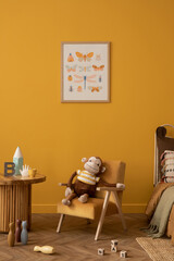 Warm and cozy kid room interior with mock up poster frame, yellow wall, orange armchair, plush toys, wooden block toys, coffee table, plaid, cup and personal accessories. Home decor. Template.