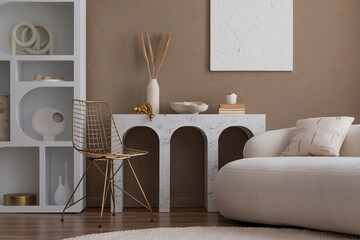 Elegant composition of warm living room interior with mock up poster frame, boucle sofa, marble console, white rack, vase with dried flowers and personal accessories. Home decor. Template.