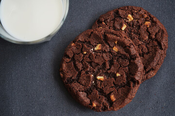 Chocolate chip cookies with a glass of milk on a gray table