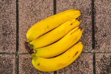 ripe bananas on a red floor tiles