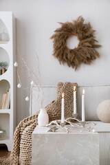 Domestic and cozy christmas living room interior with corduroy sofa, white shelf, candlestick with...