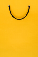 Yellow gift bag with black handles and a place for text.Black Friday sale. Creative background...