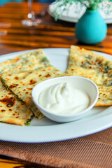 Delicious gourmet flat bread kutabs with herbs and cheese on a plate