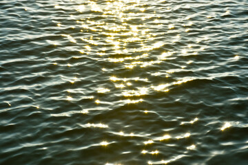 夕日の光を浴びてキラキラと黄金色に光り輝く海の波景色