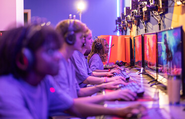 Team of professional e-sports players playing video games at cyber gaming tournaments indoors -...