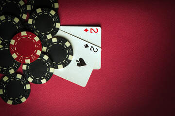A gambling game of poker with a winning combination of one pair. Cards with chips on a red table in a poker club. Space for advertising