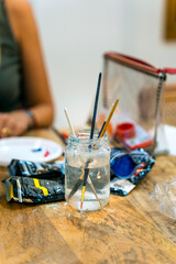 Drawing and painting classes. Pot with water and brushes. School supplies.