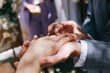 During a wedding, the bride and groom exchange wedding rings. Hand close-up