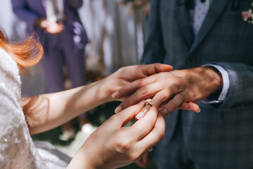 During a wedding, the bride and groom exchange wedding rings. Hand close-up - Powered by Adobe
