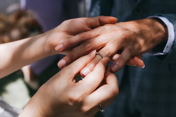 During a wedding, the bride and groom exchange wedding rings. Hand close-up