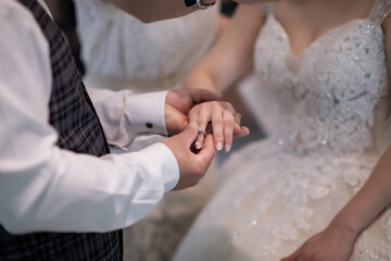 During a wedding, the bride and groom exchange wedding rings. Hand close-up