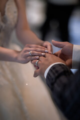 During a wedding, the bride and groom exchange wedding rings. Hand close-up