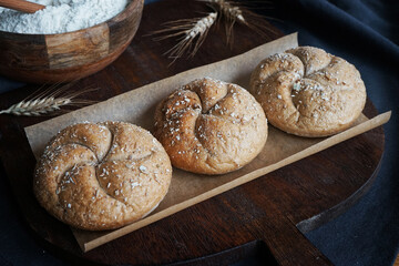 Fresh bread on the background of a plate with flour, a bottle of butter and eggs