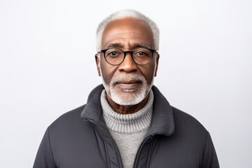 Obraz premium The portrait shows a happy and confident elderly man in his 70s with a cheerful and stylish disposition against a white background.