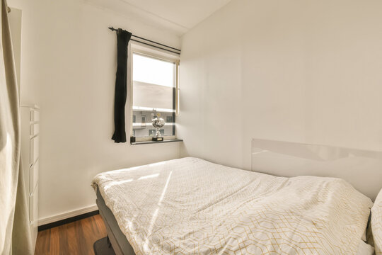 White bedroom with bed and trophy on window