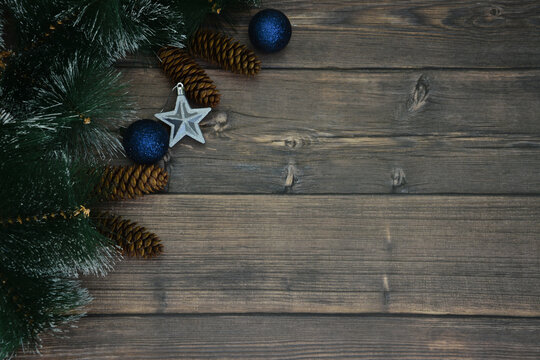 wooden board with fir branches, blue spheres and cones copy space  