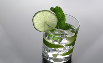 Fototapeta premium Mojito cocktail with vodka leaf mint and lime pint printing for skinned kitchen background. Interior bar products home furnishings trendy design black gray gradient sliced fruits and ice.