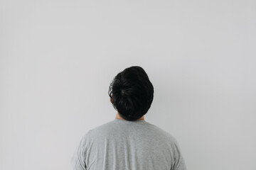 Back side, rear view of Asian man wear grey, haircut done. standing and thinking something,...
