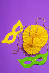 Festive Mardi Gras masquerade purple background. Fat Tuesday carnival, masks, beads, traditional decor