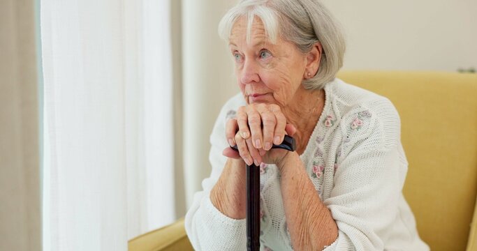 Senior Woman, Cane And Thinking On Home Sofa To Remember Memory And Relax In Retirement. Serious And Sad Elderly Person Or Old Lady With A Disability At Nursing Facility With Alzheimer And Depression