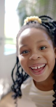 Vertical video portrait of happy african american girl with braided hair smiling, slow motion
