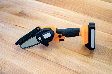 small accumulator chainsaw to trim broken branches of a tree