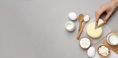 Dairy products on a wooden board, on a gray background.