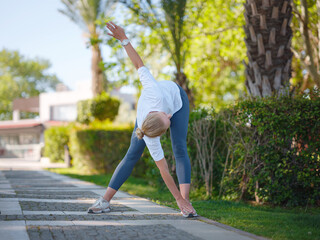 idea of healthy lifestyle and sports in a modern city. Female jogger. Fit young Caucasian woman stretching muscle in park before running and enjoying healthy outdoor. Fitness girl in public park.