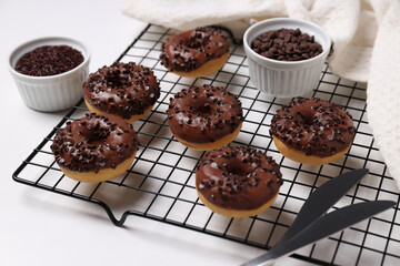 Preparation of chocolate donuts on a light background.