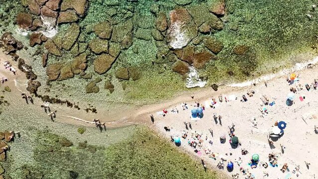 L'istmo di sabbia che collega Isola Bella e la spiaggia di Taormina. Il mare della Sicilia, Italia. 
Vista dall'alto dell'acqua trasparente e della spiaggia piena di bagnanti
