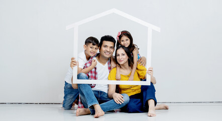 Roof, portrait and happy family with home sign board while sitting in the living room of their...