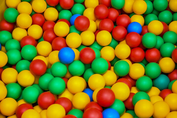Fototapeta na wymiar Color plastic balls on children's playground. Playtime in kindergarten. Background texture of multi-colored plastic balls on playground