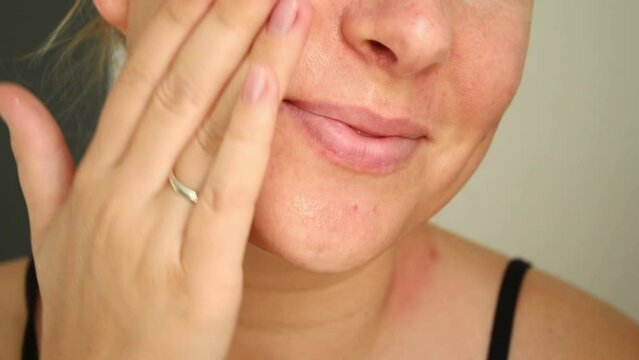 Close up portrait of caucasian woman applying face serum on skin, face and skin 