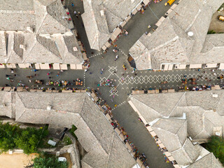 Aerial Top view Drone Shot of the central streets in Gjirokastra, Albania. Crowded Center, Souvenir shop, Cafe, Tourist