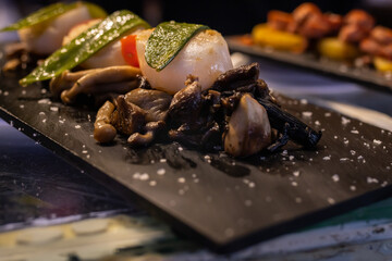 Spanish tapas of sautéed mushrooms with fried bell pepper and grilled cuttlefish
